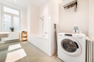 une salle de bains blanche pourvue d'un lave-linge. dans l'établissement Smile Apartments Döbling, à Vienne
