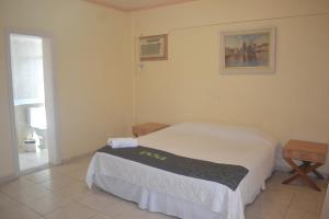 een kleine slaapkamer met een bed en een raam bij Hotel Canto do Atlântico in Guarujá