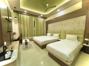 Habitación de hotel con 2 camas y lavamanos en Hotel KUBER PALACE ! PURI near-sea-beach-and-temple fully-air-conditioned-hotel with-lift-and-parking-facility en Puri