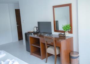 a desk with a computer and a mirror at RoomQuest Kalim Beach in Patong Beach