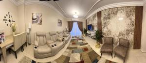 Madinaty的住宿－Luxurious VIP apartment in Madinaty furnished with high end hotel furniture，一个带沙发和椅子的候客室的沙龙