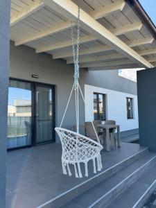 a swinging chair on a patio with a table at Focsani Casa in Cîmpineanca