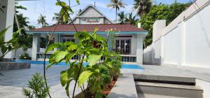 - un bâtiment avec une piscine en face dans l'établissement Magnolia Guesthouse Varkala, à Varkala