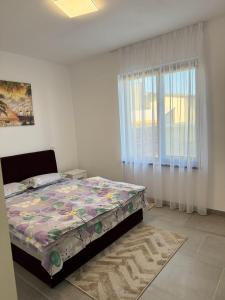 a bedroom with a bed and a window at Casacris Studio Carnabel SRL in Cîmpineanca