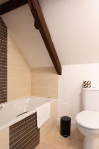 a bathroom with a bath tub and a toilet at Colthorn Farm Cottage By Aryas Properties - Oxford in Oxford