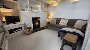 a living room with a couch and a fireplace at Beach Hill Cottage in Portloe