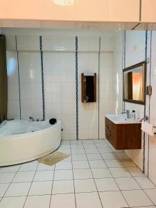 a white bathroom with a tub and a sink at TRMOTEL in Matola
