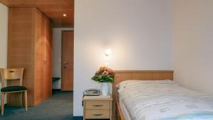 sypialnia z łóżkiem i stołem z wazonem kwiatów w obiekcie Hotel und Gasthaus Bad Gonten w mieście Gonten