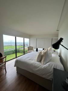 una camera da letto con un grande letto con una grande finestra di Spacious and Cozy Home with Ocean Views a Lifford