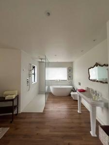 a bathroom with a tub and two sinks and a bath tub at Spacious and Cozy Home with Ocean Views in Lifford