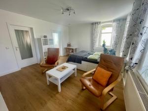 ein Schlafzimmer mit einem Bett, einem Sofa und einem Tisch in der Unterkunft gemütliches Appartement - 20 min bis Dresden in Leppersdorf