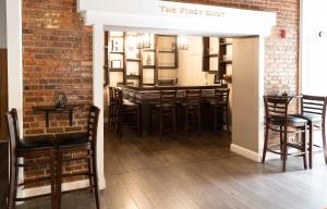 ein Restaurant mit einer Bar mit einer Backsteinwand in der Unterkunft Hunter Arms Hotel in Saint Cloud