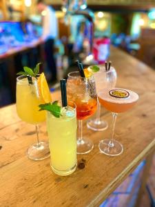 a group of four cocktails sitting on a bar at The Village Inn in Longframlington