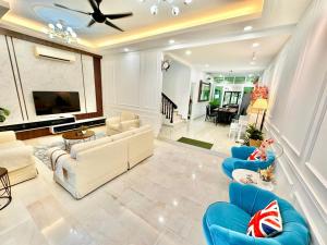 ein Wohnzimmer mit blauen Sofas und einem TV in der Unterkunft 38 villa homestay in Muar