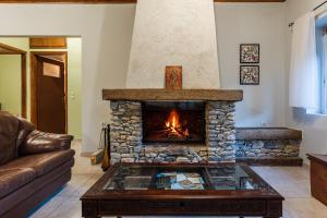 a living room with a stone fireplace at Taygetos Relaxing Cottage in Poliána +24 photos