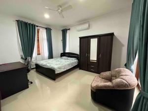 1 dormitorio con 1 cama y 1 silla en Beauty World Villa - Gampaha en Gampaha