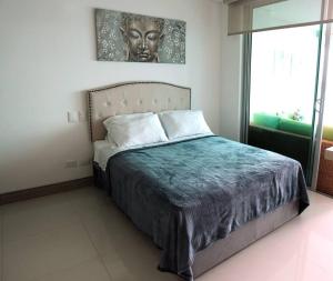 um quarto com uma cama com uma cabeceira e uma janela em Palmetto Sunset 2903 with an amazing ocean view em Cartagena de Indias