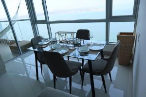 uma mesa de jantar e cadeiras num quarto com janelas em Palmetto Sunset 2903 with an amazing ocean view em Cartagena de Indias