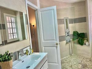 a bathroom with a sink and a shower with a mirror at Las Brisas 1 by SunHousescanarias in Las Palmas de Gran Canaria +34 photos