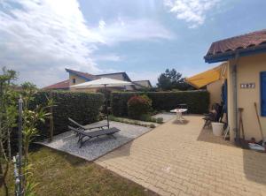 Village Océlandes 187 في سان جوليان-أون-بورن: مقعد بجانب منزل فيه مظله