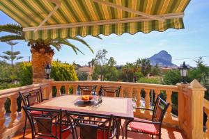 a patio with a table and chairs on a deck at Villa Carmen - Plusholidays in Calpe