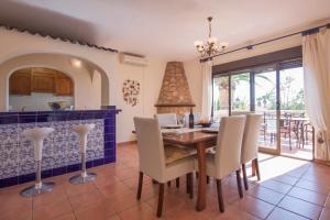 een keuken en eetkamer met een houten tafel en stoelen bij Villa Carmen - Plusholidays in Calpe