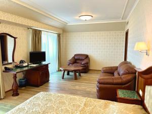 um quarto de hotel com um sofá e uma televisão em Aqua View SPA Boutique Hotel em Golden Sands