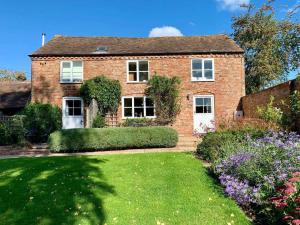 a brick house with a garden in front of it at Hop Pickers Cottage in Little Marcle