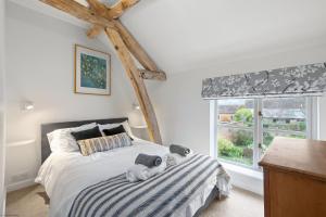 a bedroom with a bed with a stuffed animal on it at Hop Pickers Cottage in Little Marcle