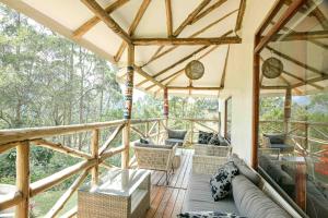 a screened in porch with a couch and chairs on it at Gorilla Safari Lodge in Rubuguli