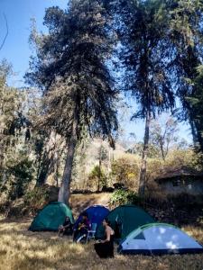 un gruppo di persone seduti di fronte alle tende di Albergue Esmeralda - Camping a Sorata