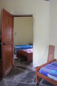 Sorata的住宿－Albergue Esmeralda - Camping，带两张床和一扇开放式门的房间