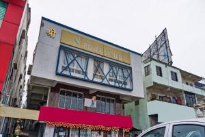 a building with a woman sitting on a balcony at Collection O Hotel Royce Studios Near Pune Airport in Pune