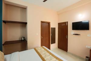a bedroom with a bed and a flat screen tv at Hotel Ginger Palace - Corporate stay business hotel in Noida