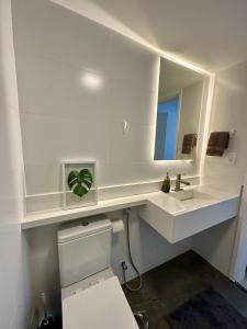 y baño con lavabo, aseo y espejo. en Novíssimo Apartamento à Beira-Mar en Río de Janeiro