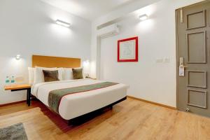 Habitación de hotel con cama y puerta en Super Townhouse 1092 Surajkund, en Faridabad