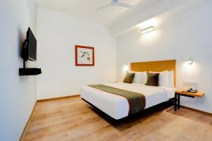 Habitación de hotel con cama y TV en Super Townhouse 1092 Surajkund, en Faridabad