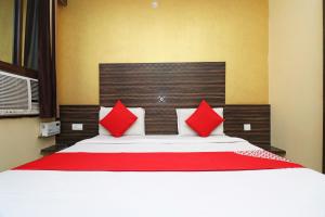 a bedroom with a large bed with red pillows at Super OYO Flagship Hotel Park Avenue in Lucknow