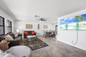 sala de estar con sofá y TV de pantalla plana en Direct Sailboat Access & Southern Exposure Heated Pool - Villa Coconut Hideaway - Roelens, en Cabo Coral