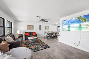 a living room with a couch and a flat screen tv at Direct Sailboat Access & Southern Exposure Heated Pool - Villa Coconut Hideaway - Roelens in Cape Coral