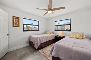 1 dormitorio con 2 camas y ventilador de techo en Direct Sailboat Access & Southern Exposure Heated Pool - Villa Coconut Hideaway - Roelens, en Cabo Coral