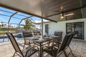 a dining room with a table and chairs on a patio at Direct Sailboat Access & Southern Exposure Heated Pool - Villa Coconut Hideaway - Roelens in Cape Coral