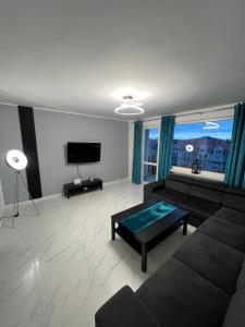 ein Wohnzimmer mit einem Sofa und einem TV in der Unterkunft Apartament z widokiem in Zgorzelec