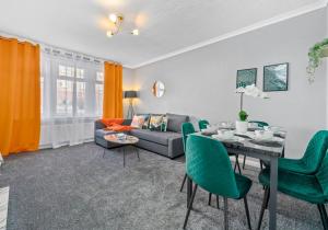 a living room with a table and green chairs at Coats Street Apartment by Klass Living Coatbridge in Coatbridge