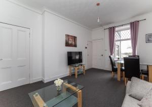 a living room with a tv and a table at Albion Apartment by Klass Living Coatbridge in Coatbridge