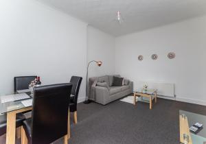 ein Büro mit einem Sofa, einem Schreibtisch und einem Stuhl in der Unterkunft Albion Apartment by Klass Living Coatbridge in Coatbridge