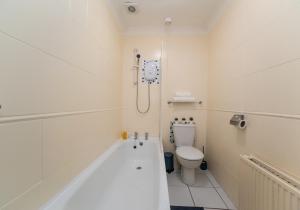 a bathroom with a bath tub and a toilet at Albion Apartment by Klass Living Coatbridge in Coatbridge