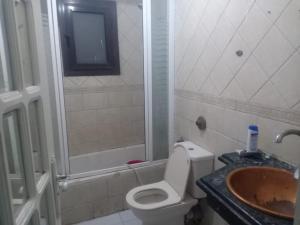 een badkamer met een toilet, een wastafel en een douche bij المريوطية الرئيسي in ‘Ezbet Abu Bakr ‘Allâm