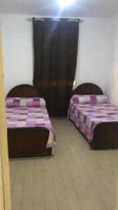 two beds sitting next to each other in a room at المريوطية الرئيسي in ‘Ezbet Abu Bakr ‘Allâm