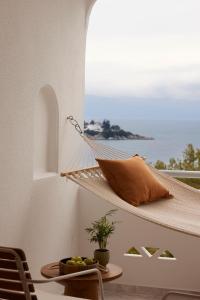 a hammock on a balcony with a view of the ocean at Brown Beach Chalkida, a member of Brown Hotels in Chalkida